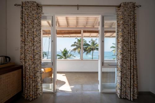 a room with a view of the ocean from a beach at Nil Ralla in Talpe