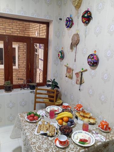 布哈拉的住宿－Al-Bashir，一张桌子,上面放着食物和水果盘