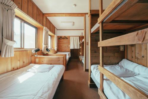 a room with two bunk beds in a train at Pension FOLKLORE in Suginosawa