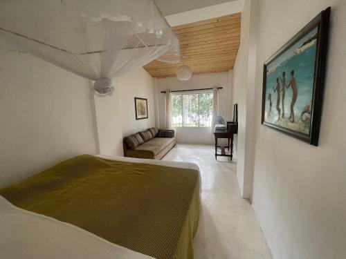 a bedroom with a bed and a couch in a room at Mountbatten's Officers mess Kandy in Kandy