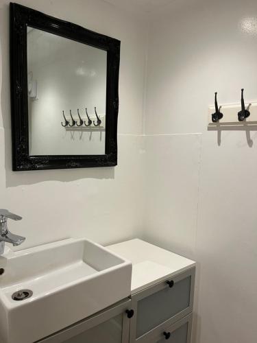 a bathroom with a sink and a mirror on the wall at The Gardeners House, Lake View & Sauna in Vreta Kloster