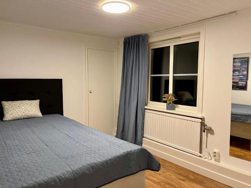 a bedroom with a bed and a window at The Gardeners House, Lake View & Sauna in Vreta Kloster