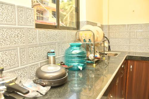 a kitchen counter with a sink with a blue bottle on it at Rajbag Residency Guest House in Canacona