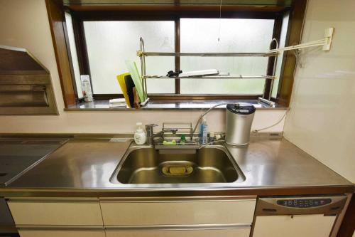 a kitchen with a sink and a window at 佐左衛門（さざえもん） in Yokosuka