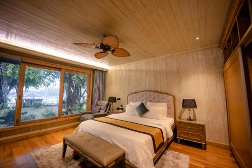 - une chambre avec un lit et un ventilateur de plafond dans l'établissement 4br Villa River Deck, Pool, Bbq & Garden, à Thuan An