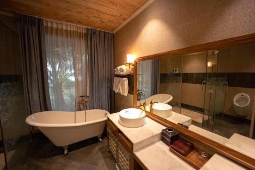 a bathroom with a tub and a large mirror at 4br Villa River Deck, Pool, Bbq & Garden in Thuan An