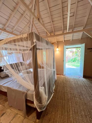 a bedroom with a bed with a mosquito net at Cabana Capybara in Mirissa