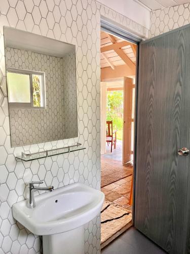 a bathroom with a sink and a mirror at Cabana Capybara in Mirissa