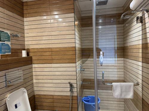 a bathroom with a glass shower with a toilet at Hotel River Retreat in Kangra