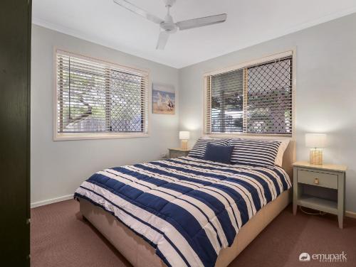 - une chambre avec un lit et 2 fenêtres dans l'établissement The Breezy Emu, à Emu Park