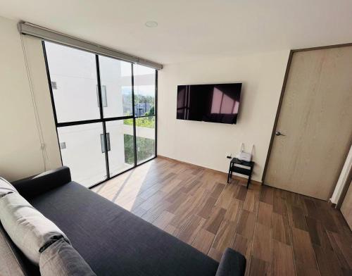 a living room with a couch and a flat screen tv at Departamento nuevo a 5 cuadras de Roma Norte. En Vértiz 253 in Mexico City