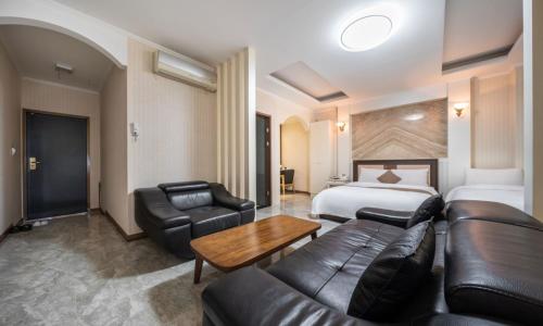 um quarto de hotel com um sofá e uma cama e um sofá e uma cadeira em Ansan Seowon Tourist Hotel em Ansan