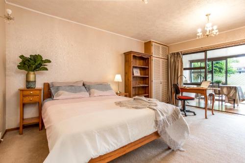 um quarto com uma cama, uma mesa e uma secretária em Prime Location! 4BR Sunny Character Home near CBD Auckland em Auckland