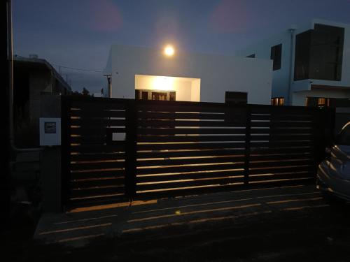 a fence in front of a building with a light on it at Cozy Lodge in Grand Gaube