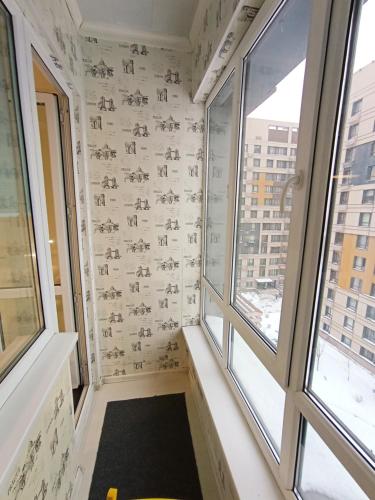um quarto com duas janelas num edifício em Светлая квартира в сердце города em Almaty