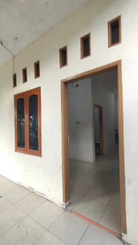 een lege kamer met twee deuren en een muur bij Almalik Kost in Serang