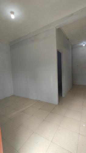 Habitación vacía con pared blanca y suelo de baldosa. en Almalik Kost, en Serang