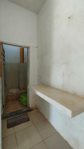 een kamer met een muur met een plank erin bij Almalik Kost in Serang