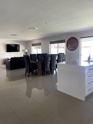a living room with a table and black chairs at Stylish Open Plan Retreat in Wagga Wagga