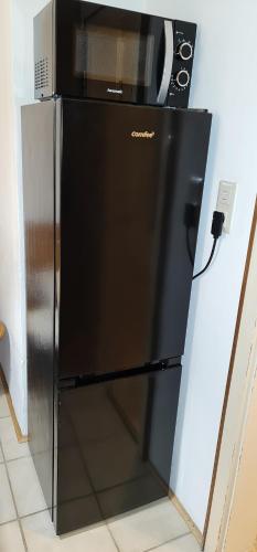 a microwave sitting on top of a refrigerator at Nomadengold in Ottobrunn