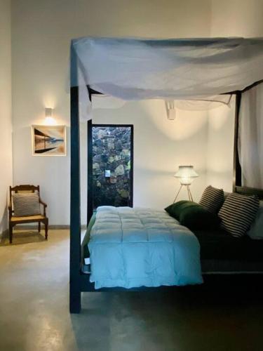 a bedroom with a bed with a blue canopy at Fika House Galle in Unawatuna