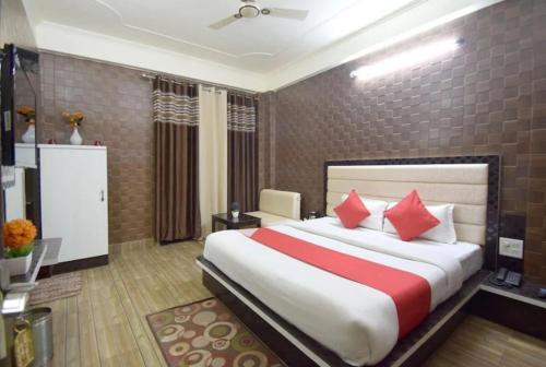 a bedroom with a large bed with red pillows at Goroomgo Om Sai Residency Bhubaneswar in Bhubaneshwar
