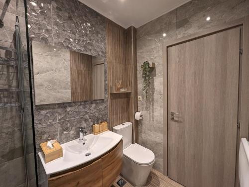 a bathroom with a sink and a toilet at Modern mint sunny house near the airport in Spáta