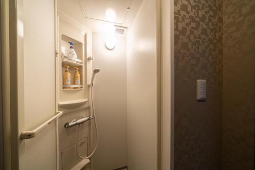 a bathroom with a toilet with a light on the door at BEPPU HOSTEL U&T in Beppu