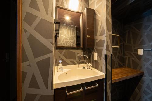 a bathroom with a sink and a mirror at BEPPU HOSTEL U&T in Beppu