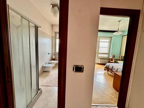Habitación con una puerta que da a un dormitorio en Finestra sulle Alpi e Golf, en Fiano