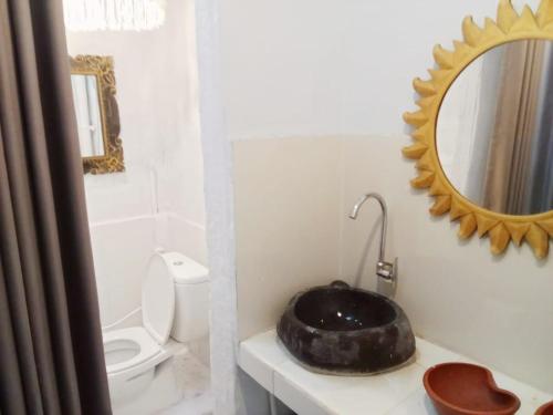 bagno con lavandino, specchio e servizi igienici di Local House Grenceng 2 a Denpasar