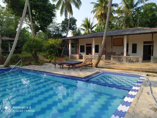 a villa with a pool and a house at Priyanka Villa in Bentota
