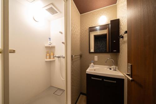 a small bathroom with a sink and a mirror at BEPPU HOSTEL U&T in Beppu