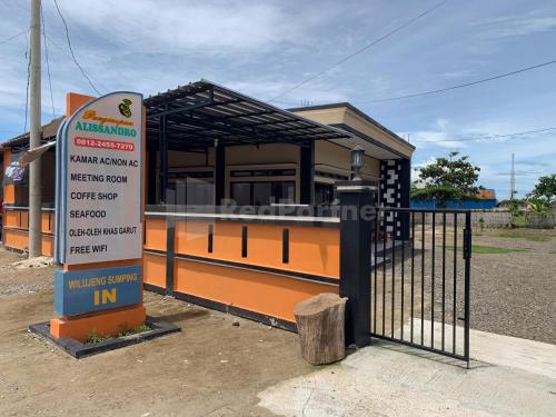 a bus stop with a sign in front of a building at RedDoorz @ Pantai Sayangheulang in Cilauteureun