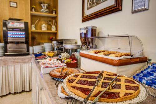 una panetteria con un tavolo con torte sopra di Hotel Tiziana a Rimini