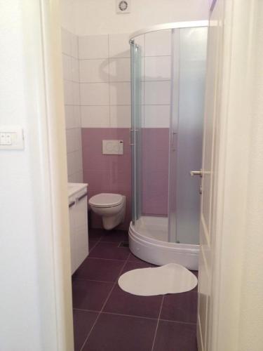 a bathroom with a shower and a toilet and a sink at Guesthouse Mala Luce Stobreč in Split