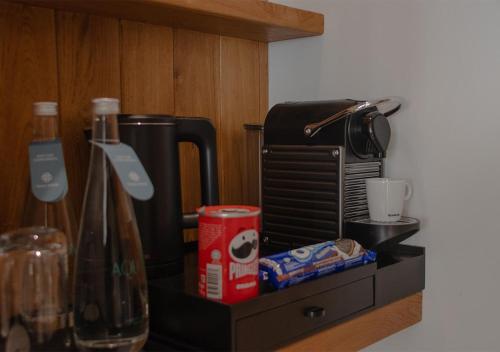 a counter top with a coffee maker and a bottle at Stone Hotels Dhiffushi in Dhiffushi