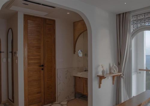 a bathroom with a wooden door and a sink at Stone Hotels Dhiffushi in Dhiffushi