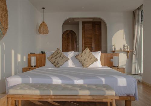 a bedroom with a large bed with white sheets and pillows at Stone Hotels Dhiffushi in Dhiffushi