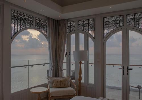 a bedroom with a room with a view of the ocean at Stone Hotels Dhiffushi in Dhiffushi