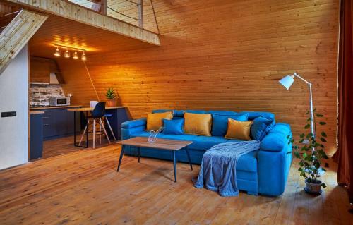 ein Wohnzimmer mit einem blauen Sofa und einem Tisch in der Unterkunft Ja ge • ჟა ღე in Tsalka