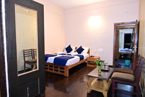 um quarto de hotel com uma cama e um espelho em Jaya Paradise em Māvalli