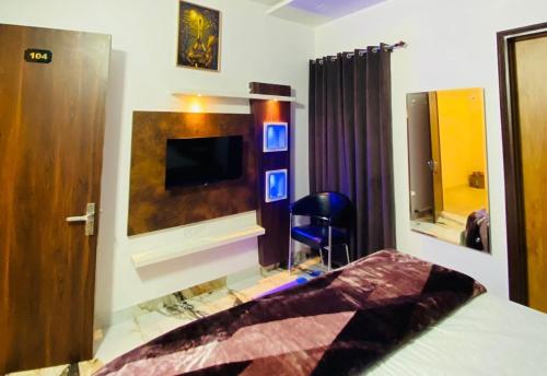 um quarto com uma cama e uma televisão na parede em Hotel Azaara em Patiala