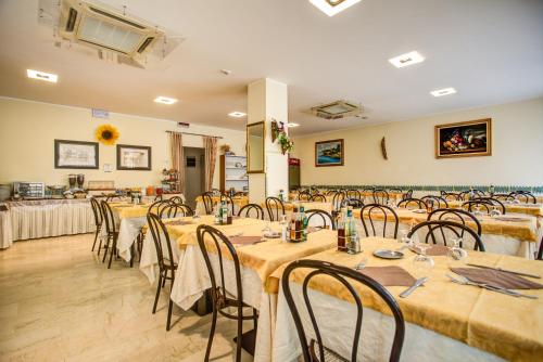 a banquet hall with tables and chairs in a room at Hotel Tiziana in Rimini