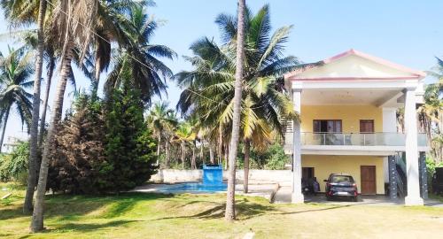 a house with palm trees in front of it at SHAN Stay home Mysore No in Mysore