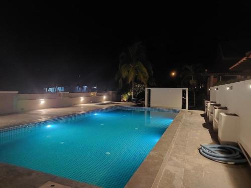 a swimming pool at night with lights on it at Jasmine Villa in Pantai Cenang