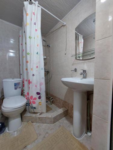 a bathroom with a toilet and a sink at Rahat Guesthouse in Dzhergalan
