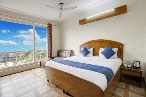 ein Schlafzimmer mit einem Bett und einem großen Fenster in der Unterkunft Hotel The Eden Park in Noida