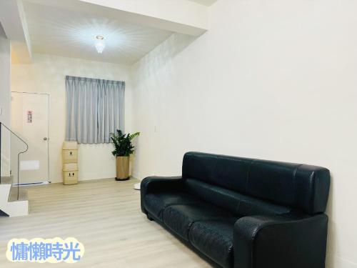 a black leather couch in a living room at Lazy Time B&B in Miaoli