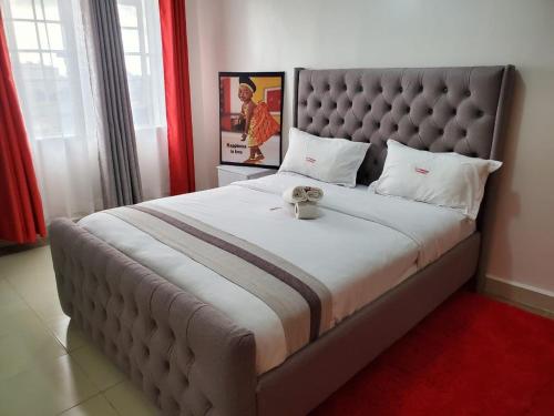 - une chambre avec un grand lit et une grande tête de lit dans l'établissement R&M APARTMENTS, à Nairobi